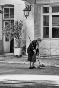 Alte Dame reinigt die Straße